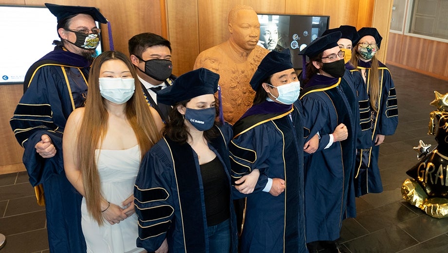 a group of law school graduates posing in masks