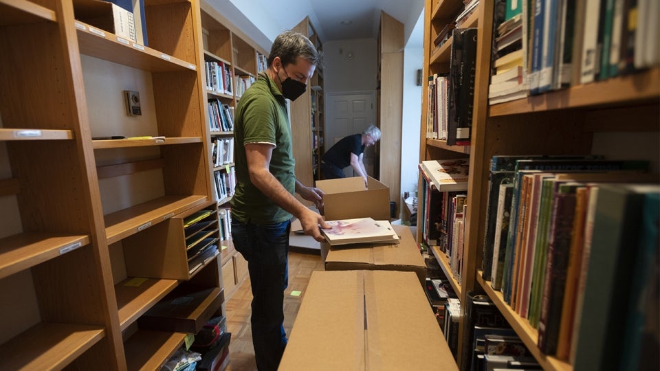UC Davis Library staff taking cookbooks off of shelves and boxing them