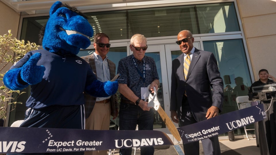 Gunrock cheers on the ribbon-cutters, from left, Rocko DeLuca, director of athletics; Bruce Edwards, donor; and Gary S. May, chancellor. (Gregory Urquiaga/UC Davis)