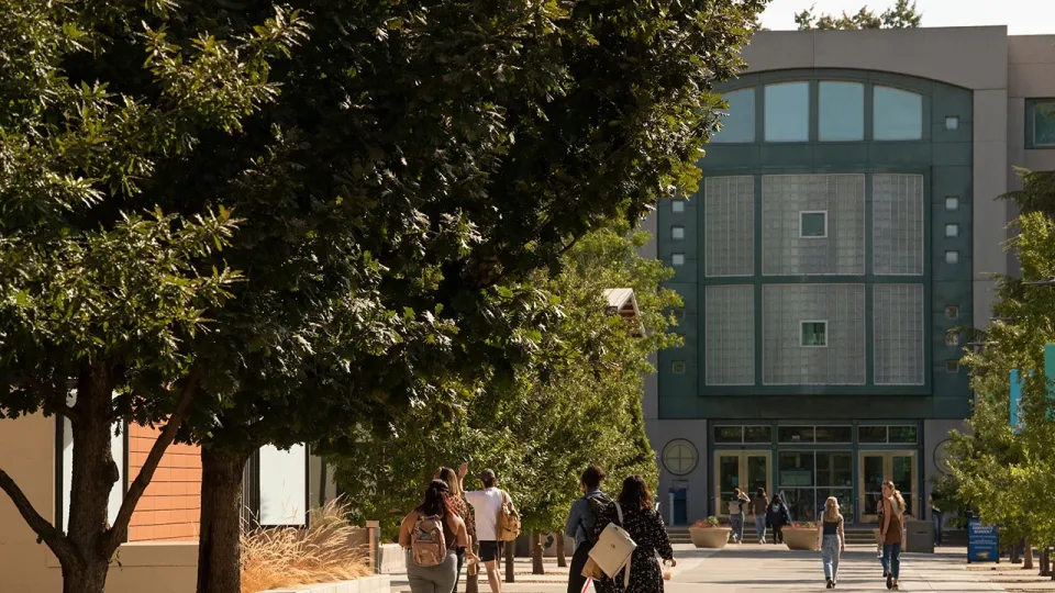 Students walk on promenade approaching Shields Library at UC Davis