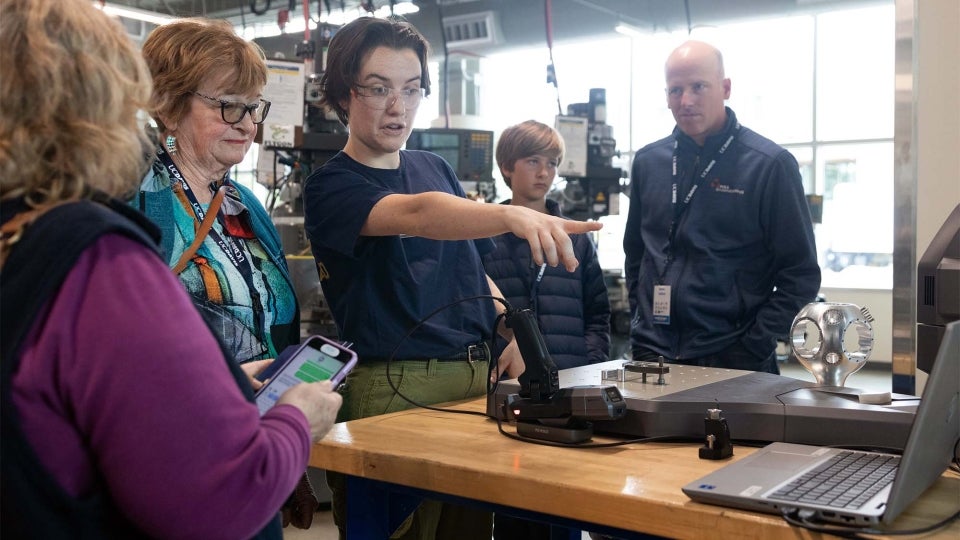 Rowan Glenn demonstrates a coordinate measuring machine, which can be used to make a digital model of a physical object. (UC Davis photo)