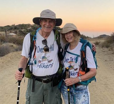 Mark and Marsha wearing hiking gear and posing on a hiking trail.