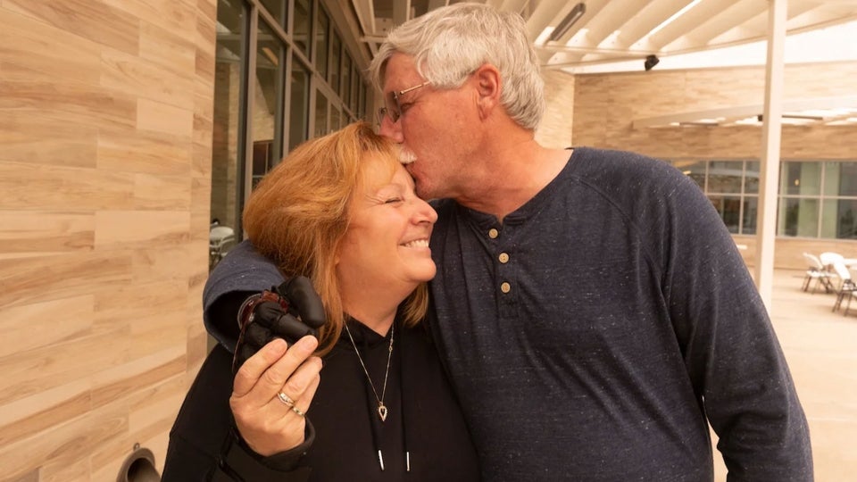 David Brockman embraces his wife, Tereasa Brockman, at UC Davis after David had a fitting for his prosthetic hand
