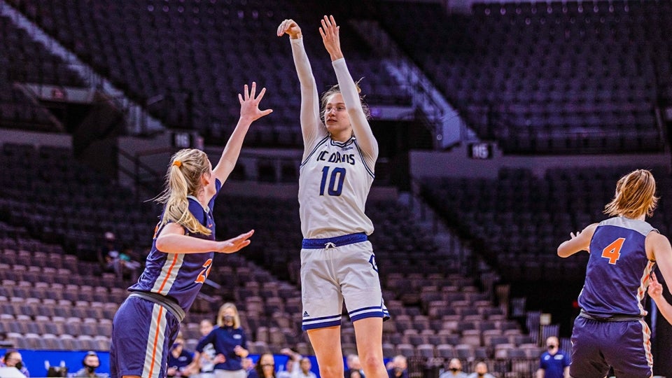 Lena Svanholm shooting a basketball towards the hoop with opposing team member playing defense