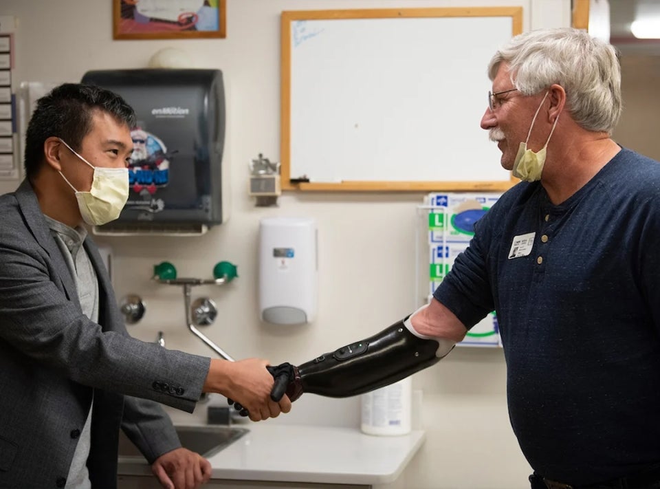 Surgeon Andrew Li shakes the prosthetic hand of former patient David Brockman