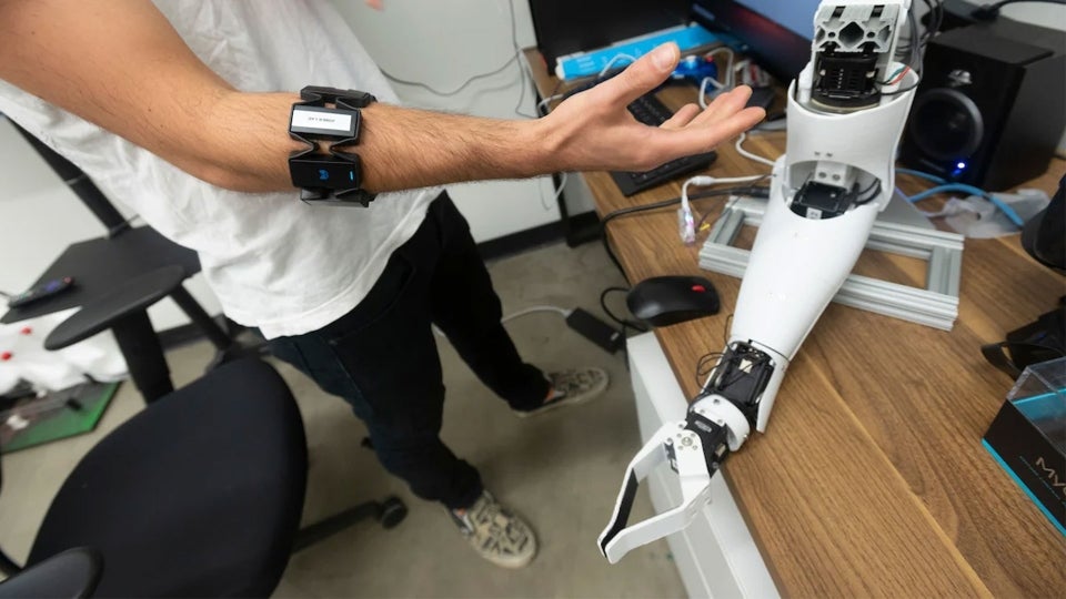 man testing a robotic arm in a lab