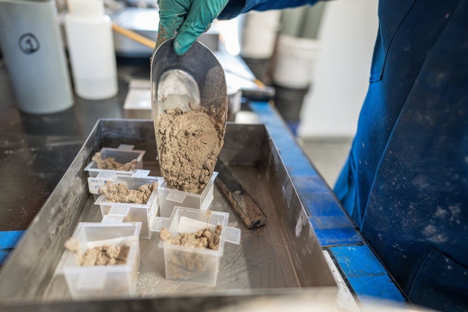 A researcher prepares test batches of geopolymer concrete made with discarded almond hulls.