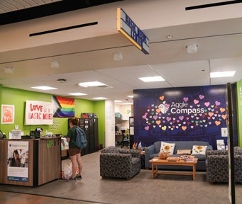 Lounge with couches, a reception desk and brightly colored blue and green walls inside the Basic Needs Center at UC Davis.