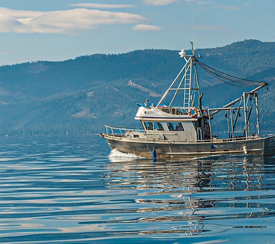 A vessel sits in the waters of Lake Tahoe with the mountains visible behind.