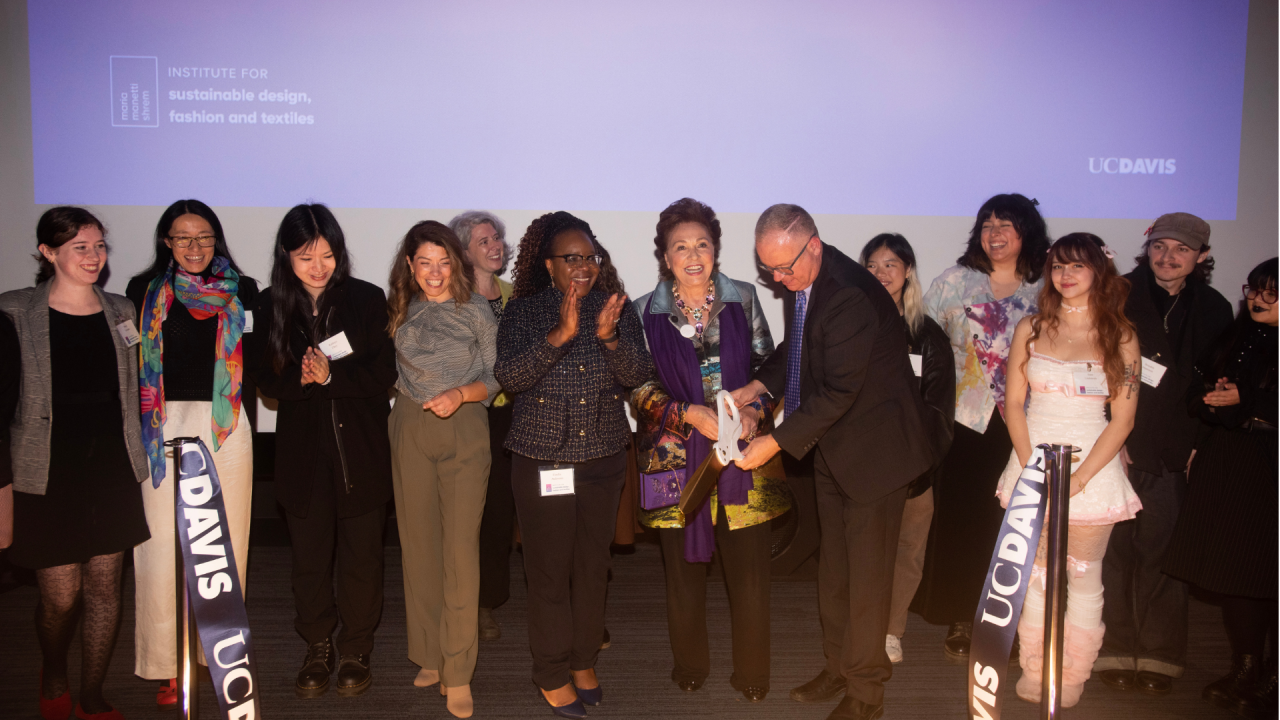 Maria Manetti Shrem and campus administrators at the ribbon cutting grand opening of the Maria Manetti Shrem Institute for Sustainable Design. They are joined on stage by design, fashion and textiles students.