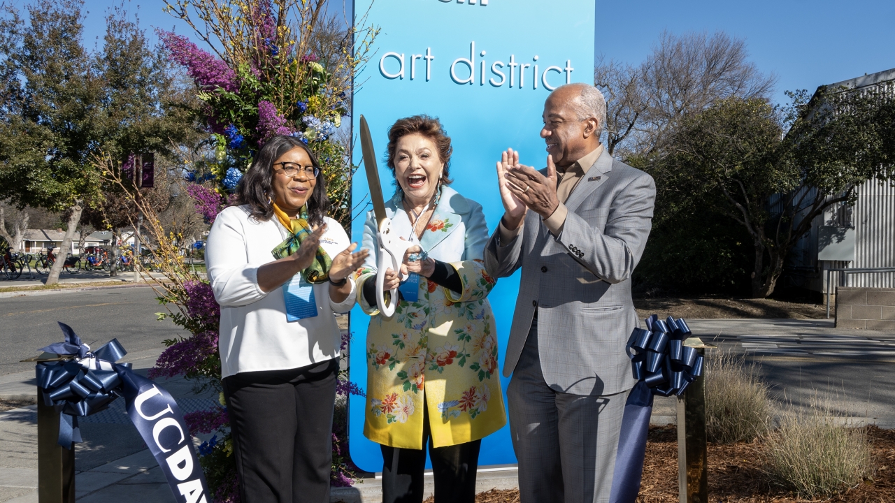 Maria Manetti Shrem, center, cuts ribbon in front of the newly named Maria Manetti Shrem Art District as UC Davis College of Letters and Science Dean Estelle Atekwana, left, and UC Davis Chancellor Gary S. May, look on.