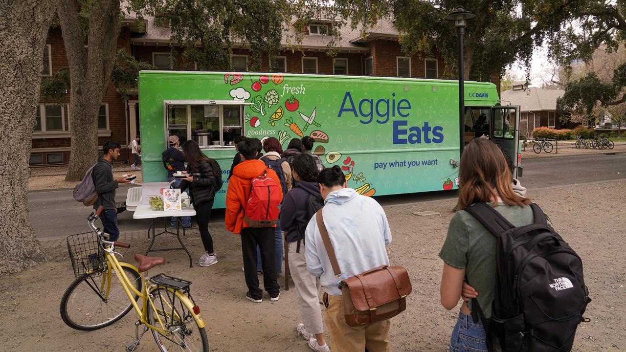 Students line up and use their smartphones to order on the first day of full service of the AggieEats food truck.