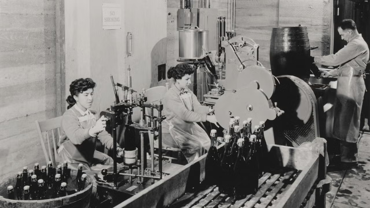 Historic photo of champagne being bottled in a plant in the 1950's.