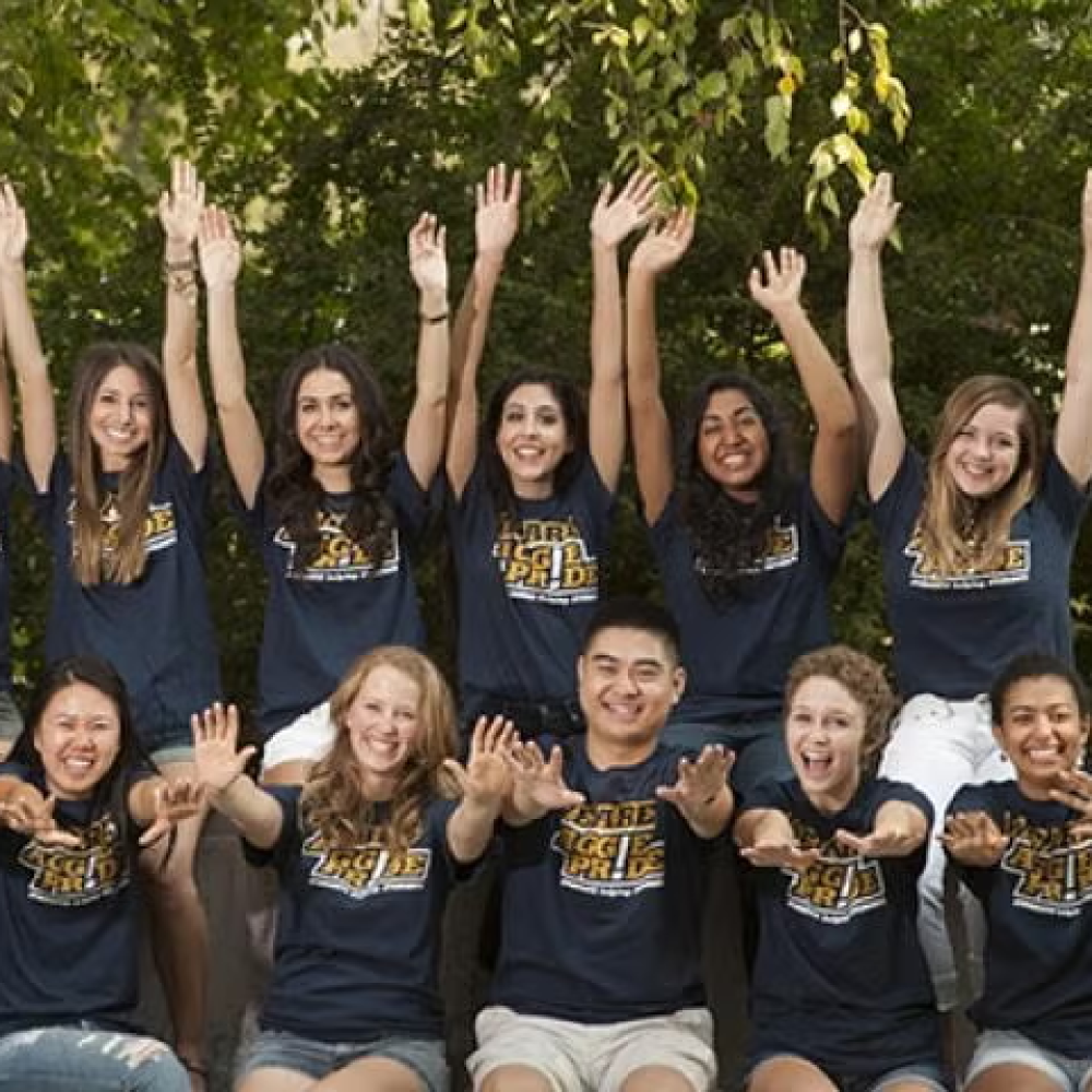 A group of students with outstretched arms.