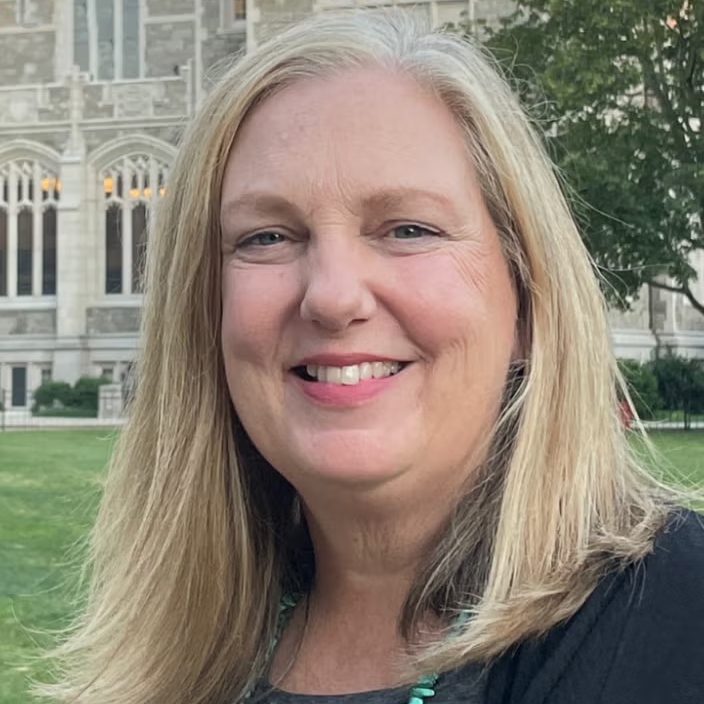 Joan Zimmermann poses in front of a historical building.