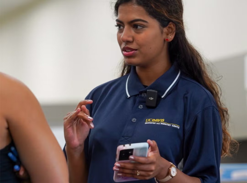 An advisor references something on the phone while speaking with another student.