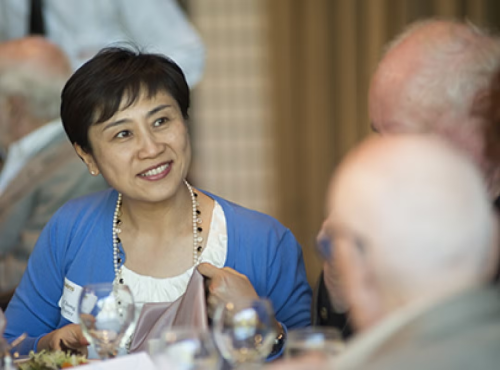AVC Chong Porter seated and in conversation with donors at an event.