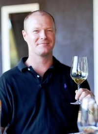 Kirk Venge '98 of Napa Valley's Venge Vineyards lifting up a glass of wine.