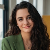 Headshot of Cora Moon wearing a green blazer.
