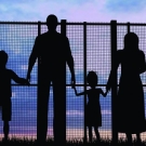 Silhouette of a family at a fence