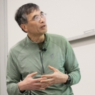Professor Zhi Ding teaches a lecture with hands clasped.